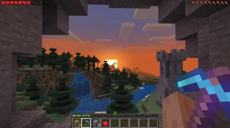 A first-person view of a blocky voxel world at sunset.